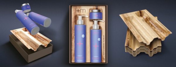 Blue Packaging Three blue cosmetic bottles with silver caps are displayed alongside a natural wooden packaging tray made from layered, wavy wood. One version shows the bottles floating above a black box with the wood insert, while another shows two tall pump bottles neatly fitted into a rectangular wooden box. The overall design combines smooth blue containers with light, textured wood for an eco-friendly, premium look.