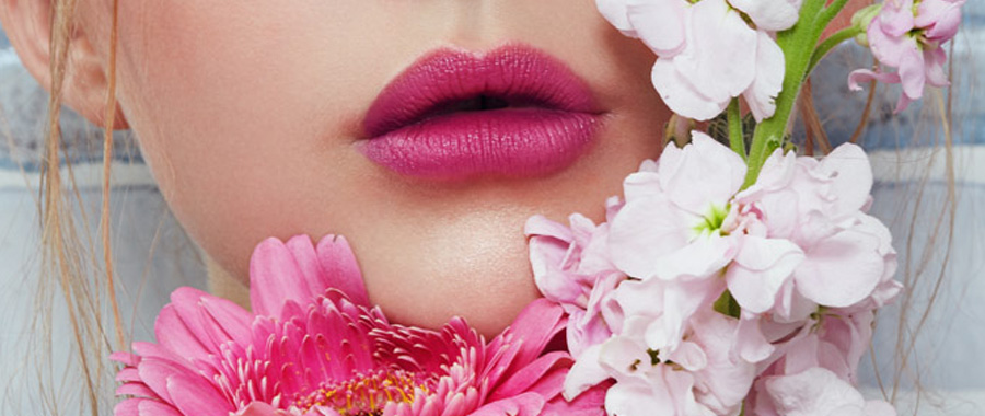 A white female’s pink lips A white female’s pink lips framed by pink and white flowers